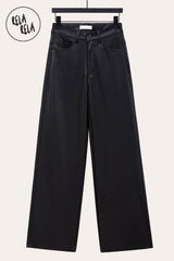 Flat lay of black faux leather trousers – wide leg and high waist design emphasizing modern tailoring.