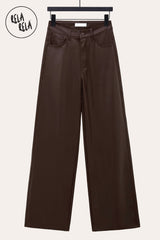 Flat lay of chocolate faux leather trousers – wide leg and high waist design emphasizing modern tailoring.