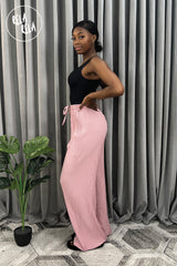 Side view of full-length dark pink plissé wide leg trousers – flattering pleated wide leg trousers elongating the legs.