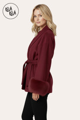 Side view of model wearing Faux Fur Cuff Wrap Coat with Waist Tie Belt in Burgundy