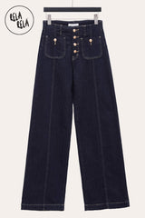 Front view of rinse blue wide leg jeans showing seamed detailing and button accents.