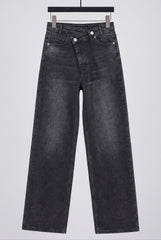 Flat lay of RELA RELA Dark Grey asymmetric waist wide-leg jeans, showing the crossed waistband, button detail and washed grey denim texture.