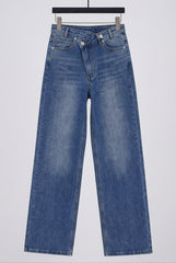 Flat lay of RELA RELA Mid Wash Blue asymmetric waist wide-leg jeans, showing the crossed waistband, button detail and washed blue denim texture.