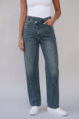 Front model view of RELA RELA Denim Blue asymmetric cross-front high-waist wide-leg jeans, showing the crossover waistband, soft stretch denim and full-length leg.