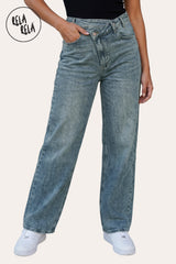 Front view of a model wearing Rela Rela Vintage Blue asymmetric waist wide leg jeans. Highlights the unique cross-front button detail and flattering high-rise sculpting fit.