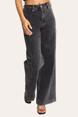 Model wearing dark grey pintuck flare jeans – stylish stretchy wide leg denim with high-rise waist and tailored finish.