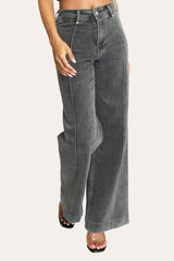 Model wearing dark grey pintuck flare jeans – stylish stretchy wide leg denim with high-rise waist and tailored finish.
