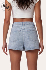 Rear view of the RELA RELA Light Blue stretchy cross-front mid-rise denim skort on body. Highlights the two clean square back pockets and the seamless integrated short underlayer. Styled with a white fitted top.