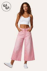 RELA RELA Pink baggy fit longline denim jorts worn on body full front view, model standing tall with both hands tucked into the front pockets, paired with a white crop top and white sneakers
