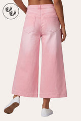 RELA RELA Pink baggy fit longline denim jorts worn on body back view from waist down, showing two back pockets and the longline below-knee hemline, captured mid-stride with one heel lifted