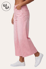 RELA RELA Pink baggy fit longline denim jorts worn on body three-quarter side profile, showing the baggy silhouette and side seam, with one hand tucked into the front pocket