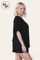 Side view of black two piece outfit – oversized top and co-ordinating shorts