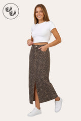 Model wearing RELA RELA Leopard stretchy denim maxi skirt with split front, styled with a white cropped tee and trainers.