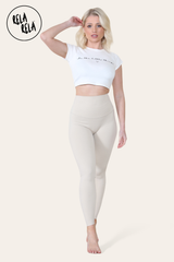 Front view of beige high waisted workout leggings on model standing upright