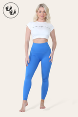 Front view of blue high waisted leggings on model standing upright
