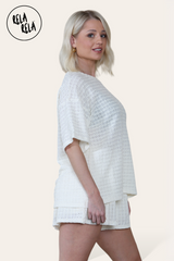 Side view of cream two piece outfit – oversized top and co-ordinating shorts